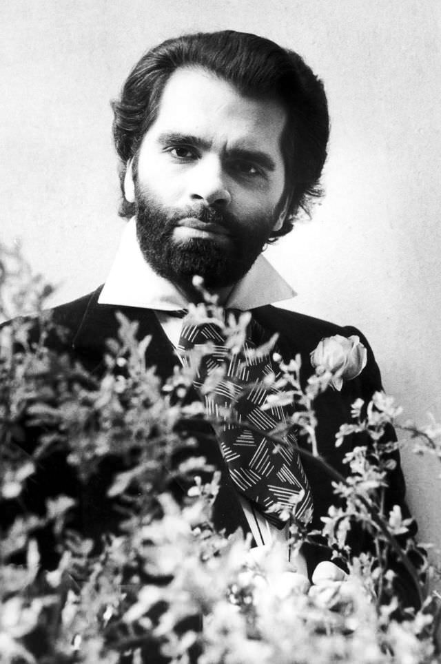 Karl Lagerfeld posing behind flowers, 1950s.