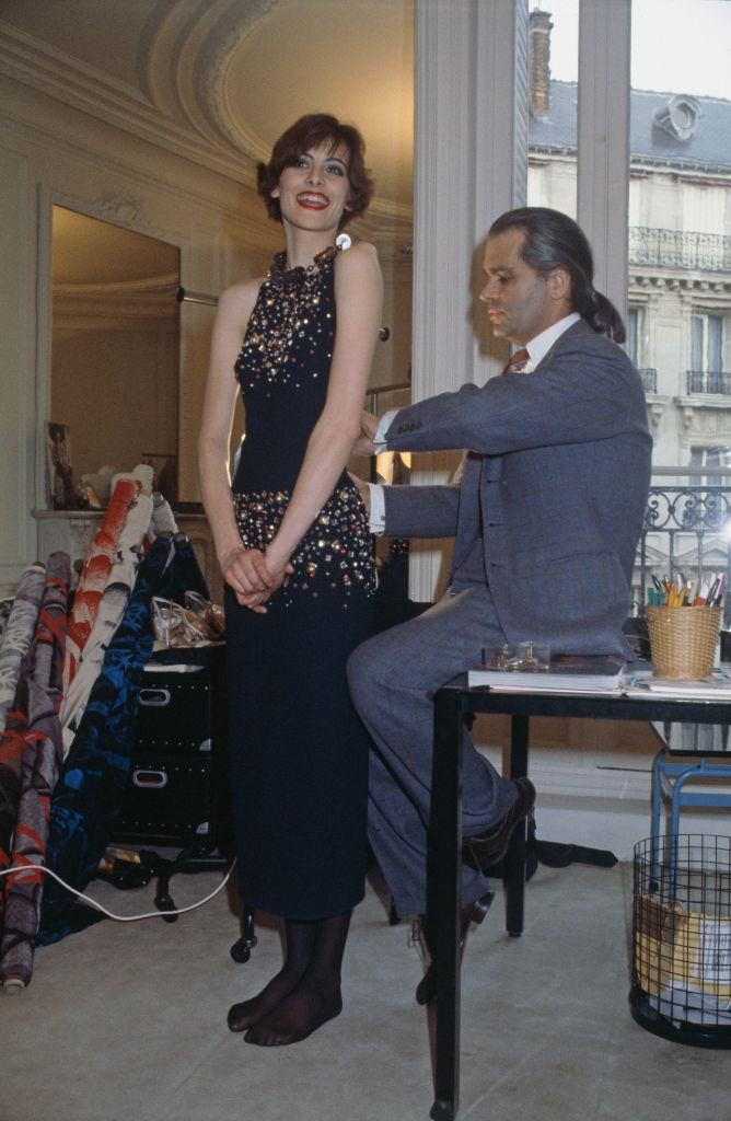 Karl Lagerfeld fits one of his designs on top model Ines de la Fressange at Chloe's Paris studio.