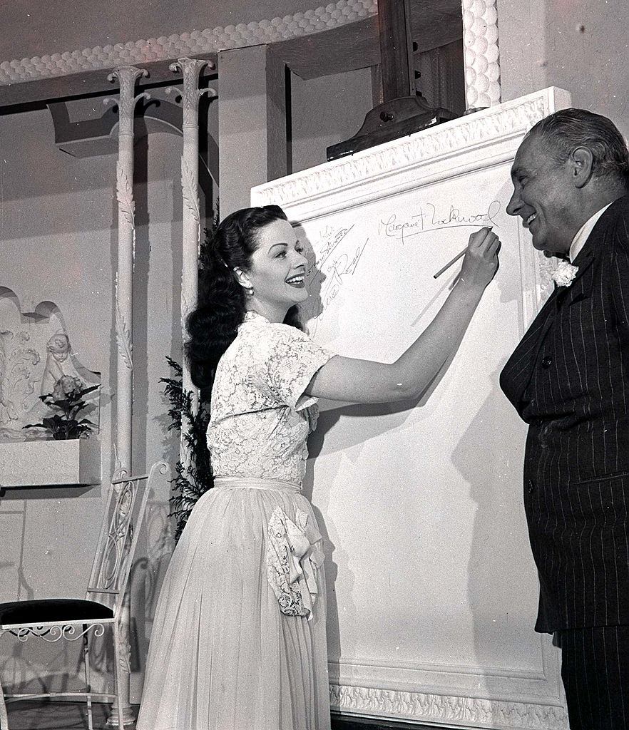 Margaret Lockwood as she signs the "Roll of Fame" watched by Henry Edwards, 1947.