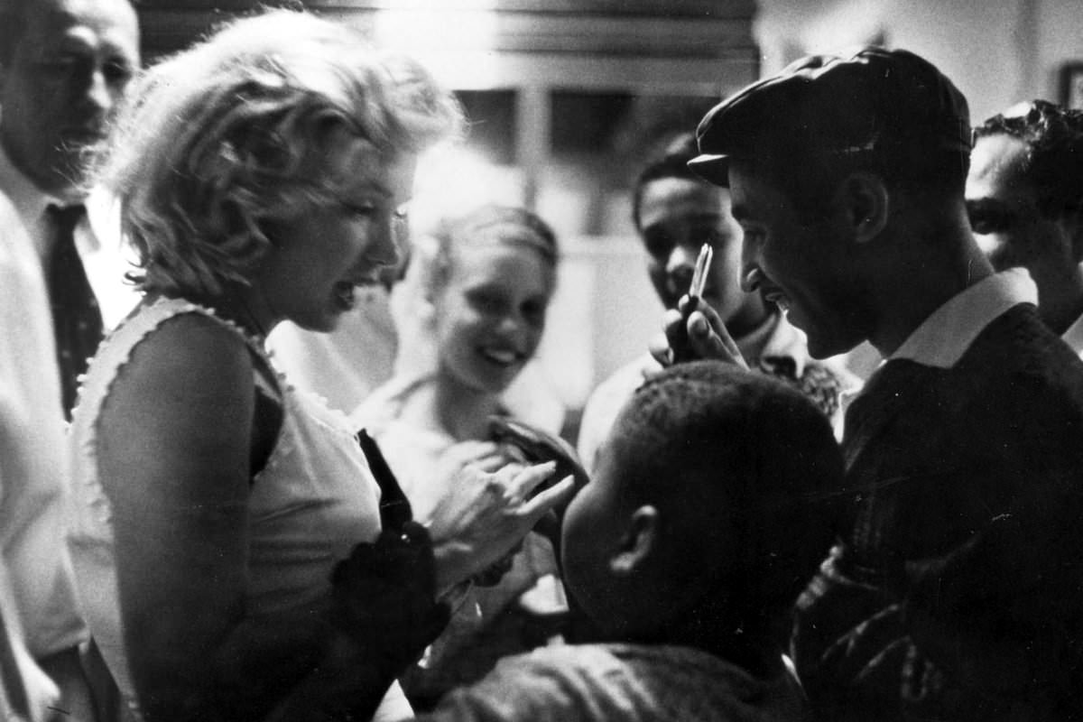 Marilyn Monroe signing autographs for her fans in a series of Candid Photographs