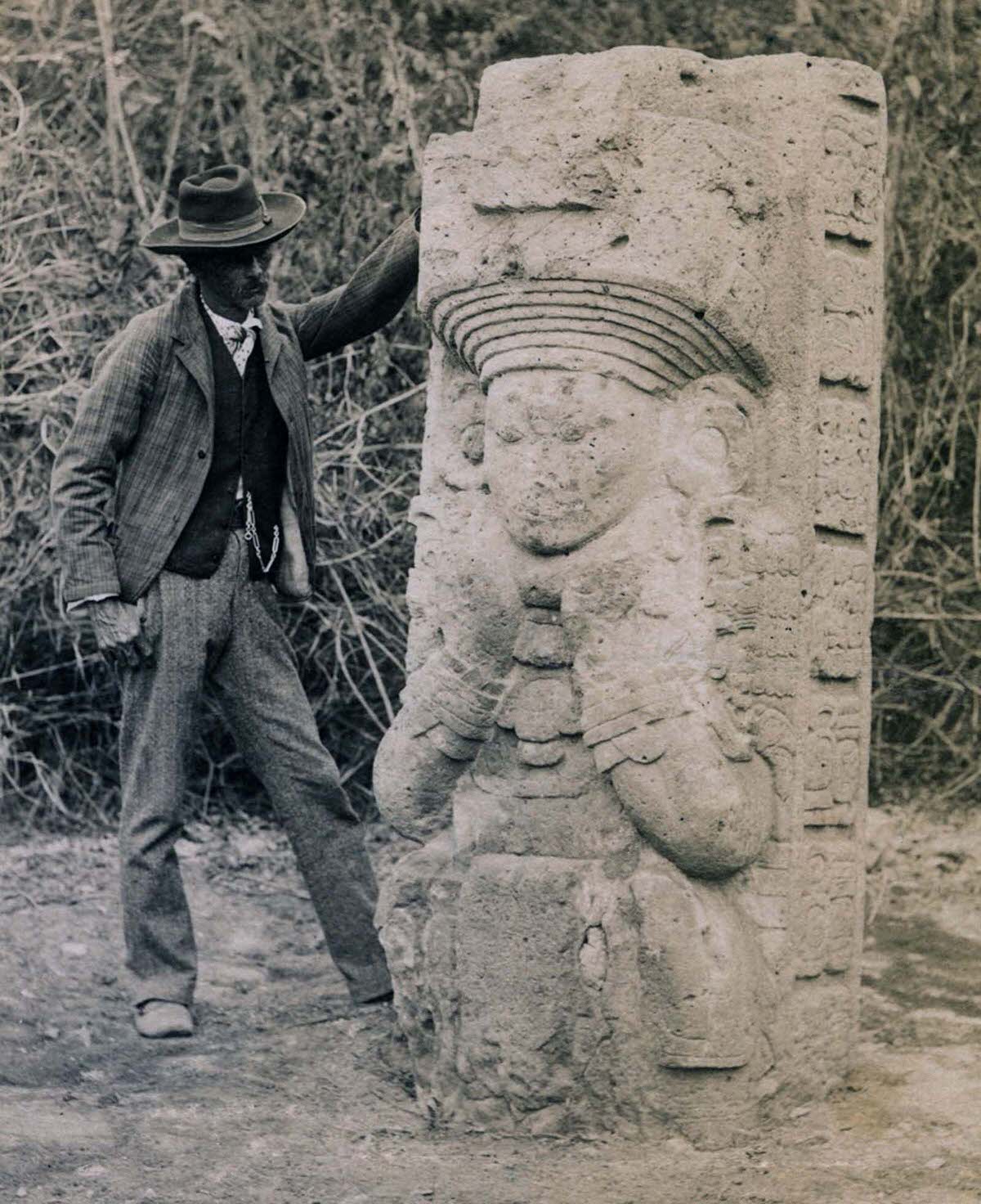 Stela 1 at Copan, Honduras, as found by Alfred P. Maudslay, 1880s. A Honduran man stands next to the stela for scale.