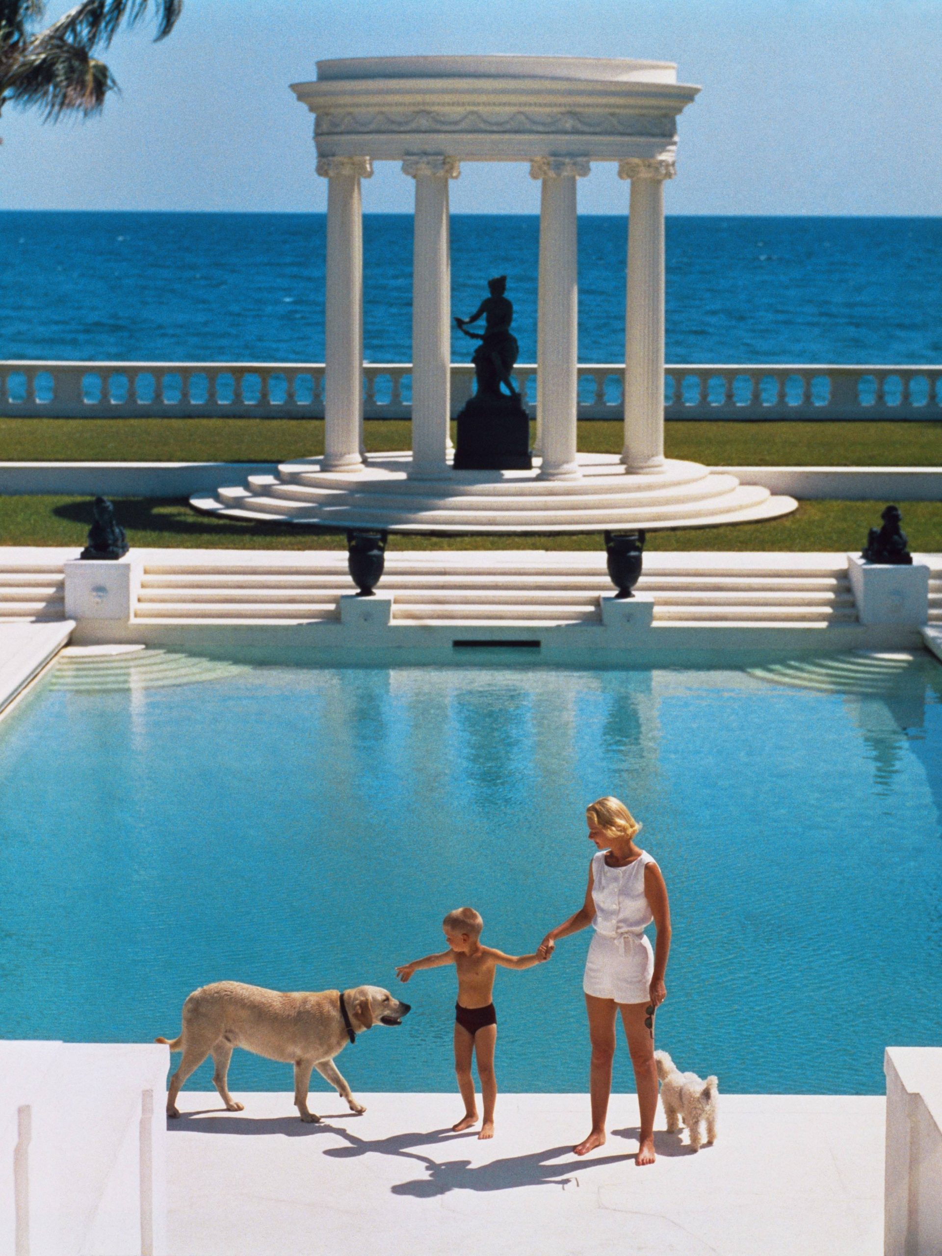 American writer C.Z. Guest and her son Alexander Michael Douglas Dudley Guest in front of their Grecian temple pool on the ocean-front estate, Villa Artemis, Palm Beach.