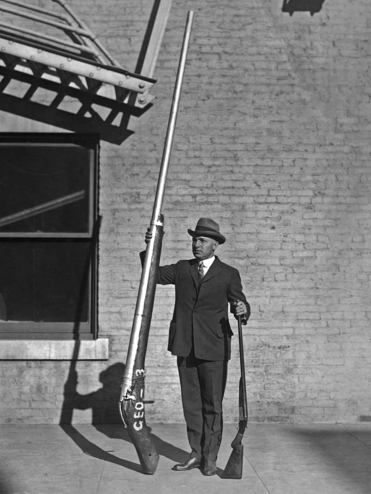 Chief United States Game Warden George A. Lawyer, with an illegal 10'9" shotgun weighing 250 pounds, which was used for duck hunting, 1920