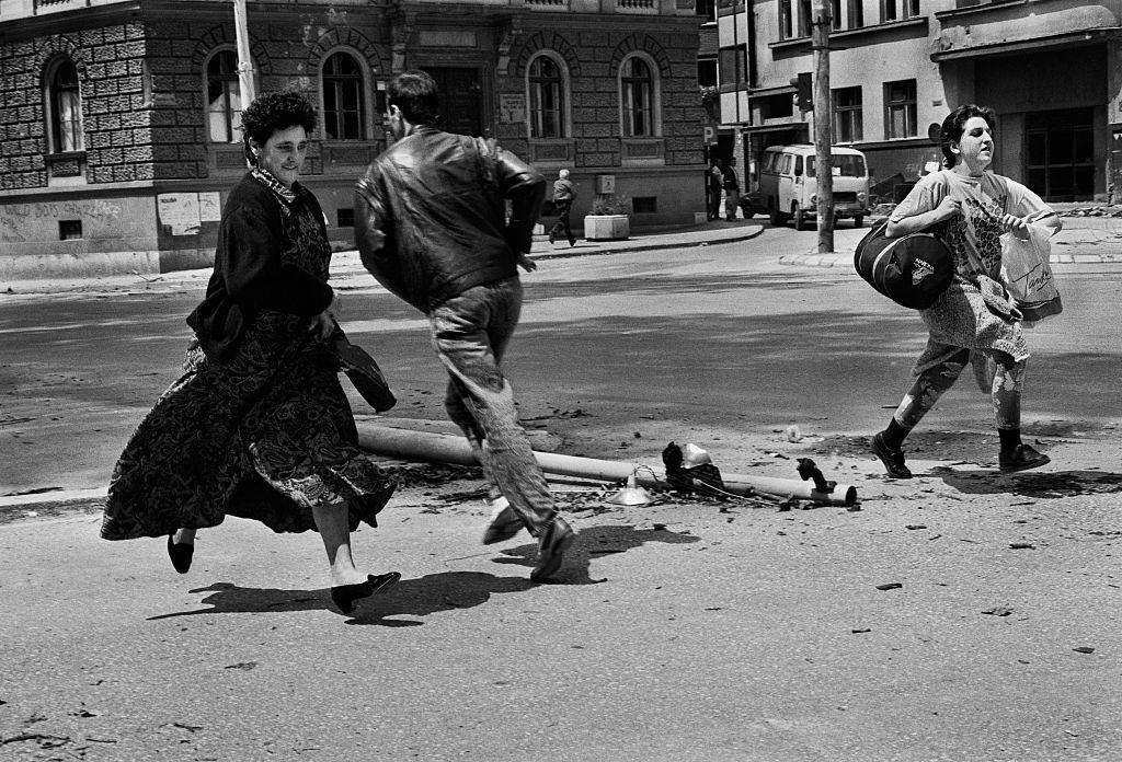People run for their lives across 'Sniper Alley' under the sights of Serb gunmen during the siege of Sarajevo, 1992.