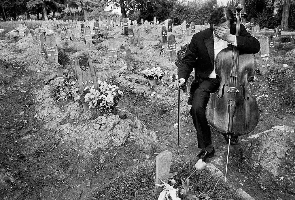 Celloist Vedran Smalovic breaks down in tears after playing a requiem to a dead friend in Hero's Cemetery, where Bosnian fighters were buried during the siege of Sarajevo, 1992.