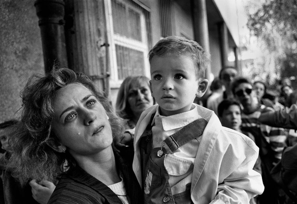 Tears of anguish for a mother as she prepares to send her confused child out of Sarajevo on a bus promised safe passage by the Serb forces during the siege in 1992.