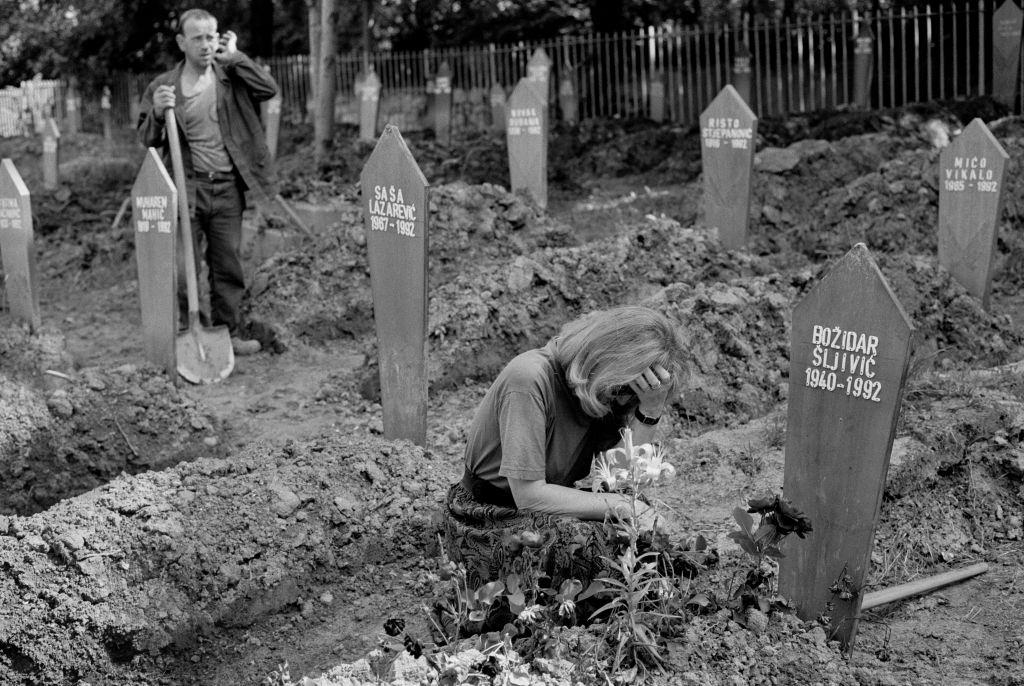 A woman grieves by a grave in the Lion Cemetery, July 1992.