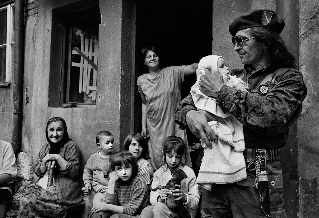 Bosnian soldier Sead Hamzic holds his 53 day old goddaughter Amila outside the family home in Sarajevo.