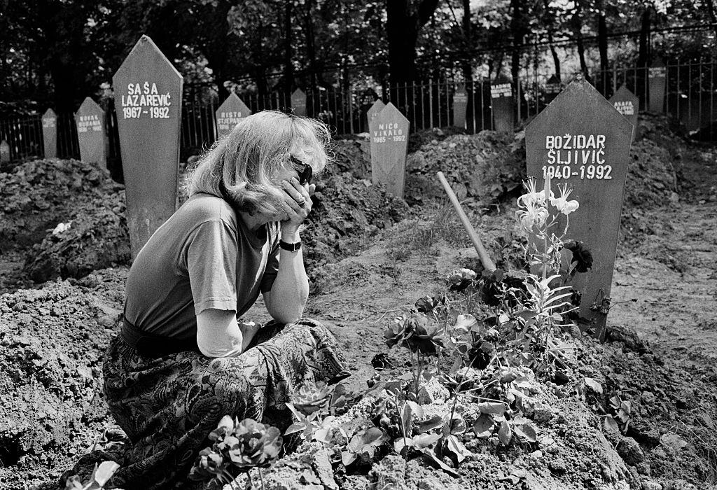 A woman grieves by a grave in the Lion Cemetery, Sarajevo, 1992.