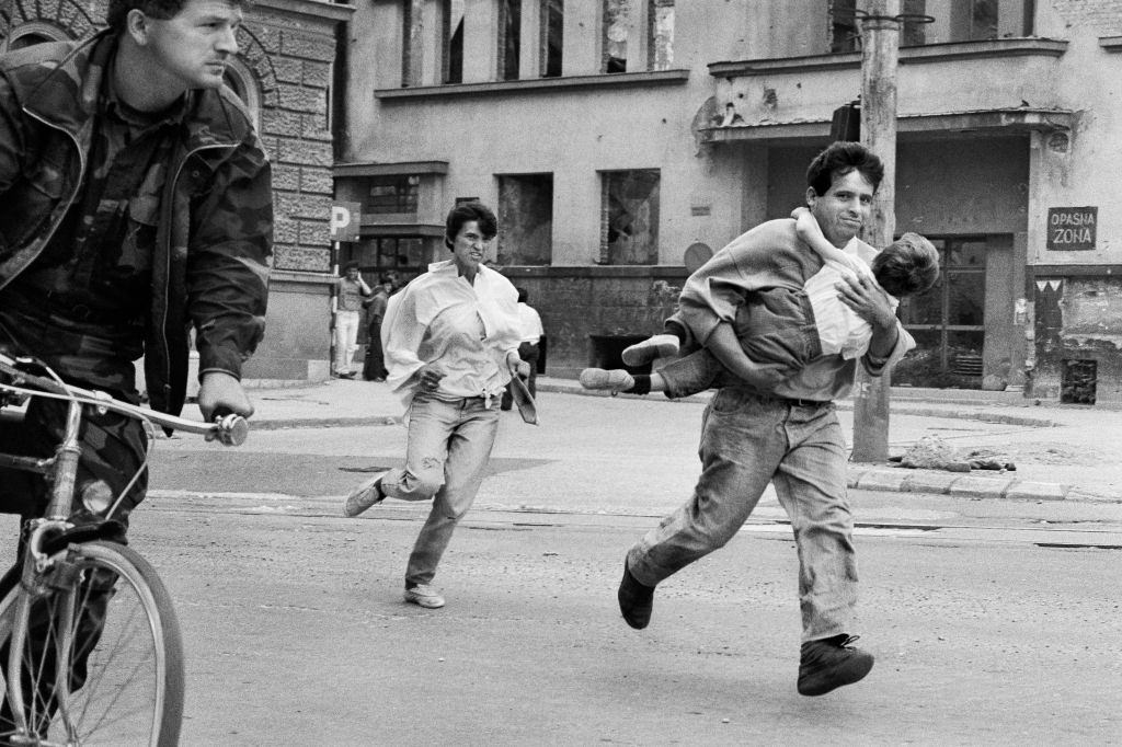 A family dash across 'Sniper Alley' to avoid gunfire during the siege of Sarajevo in 1994.