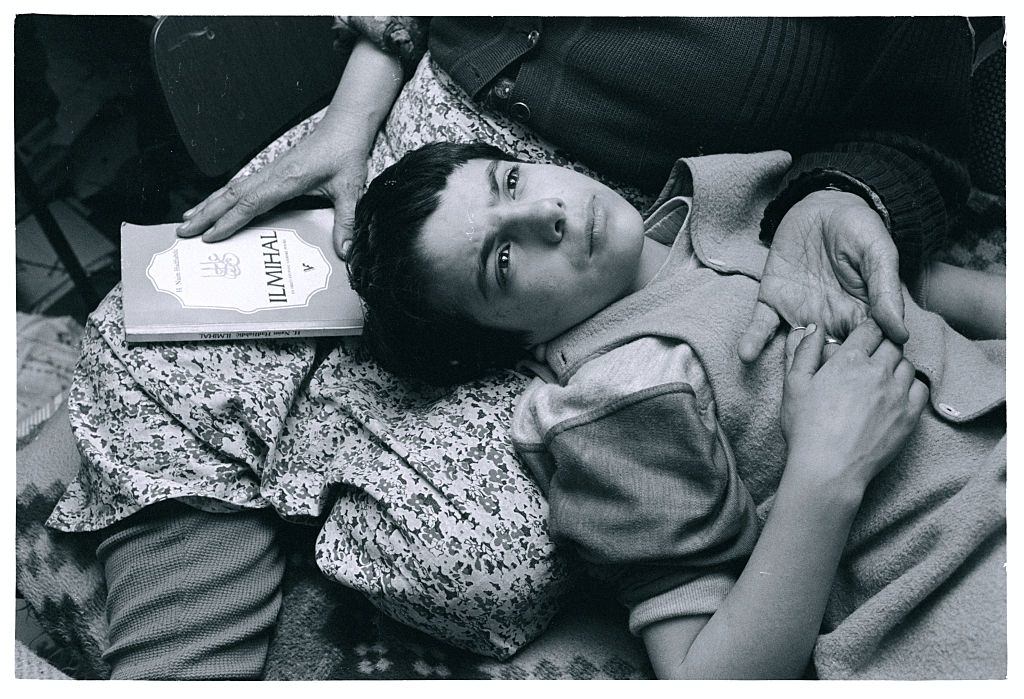 Mirza Mangajic, a 10-year-old Muslim boy, lays his head in his grandmother's lap as he prays with her.