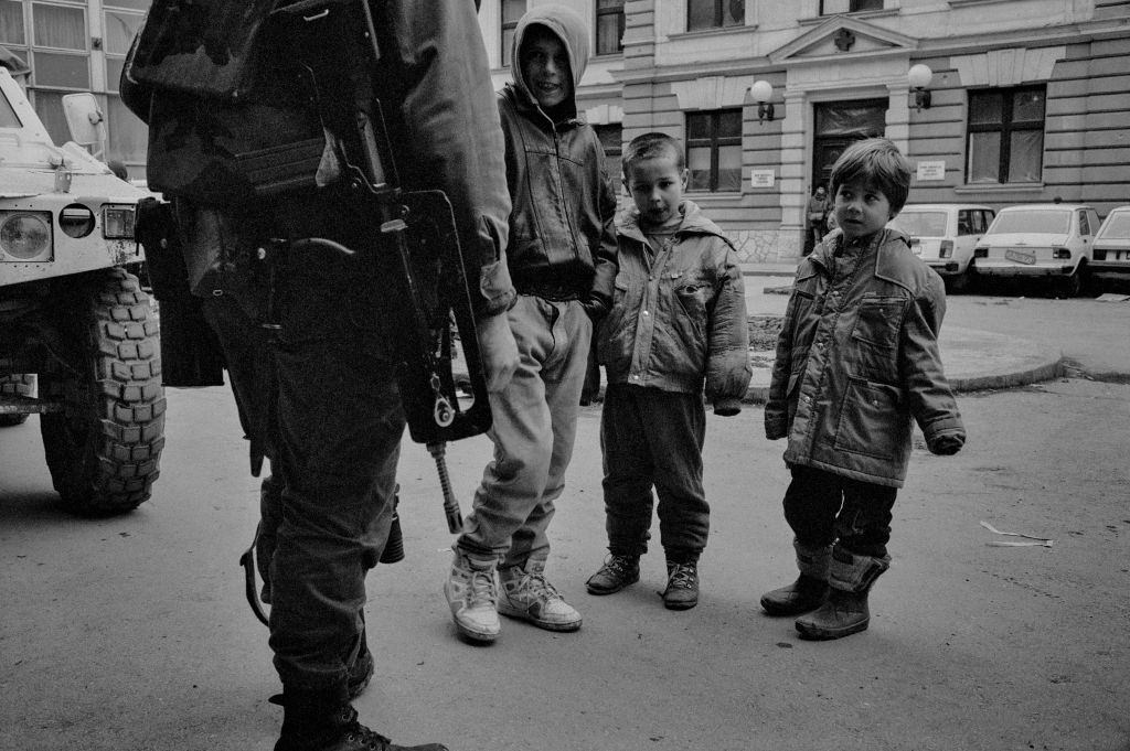 Three children standing with the soldier, 1994.