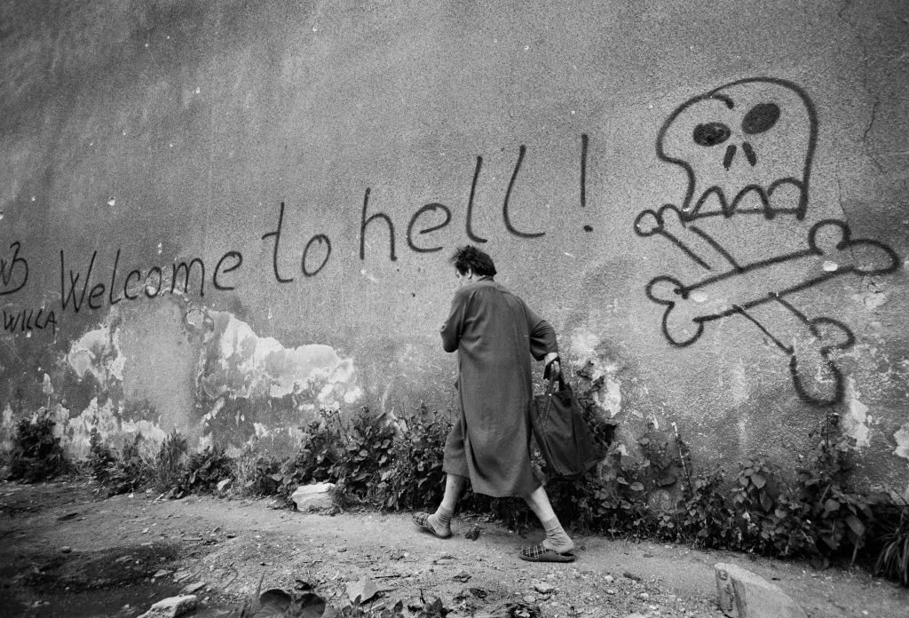 Welcome to hell - a woman hurried past graffiti in the area known as 'Sniper Alley' in Sarajevo's main thorough fare during the siege in 1992.