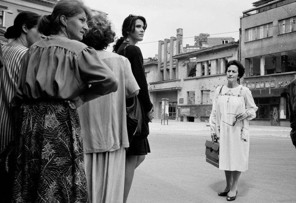 Women wait for the shooting to stop before running across 'Sniper Alley' during the siege of Sarajevo in 1995.