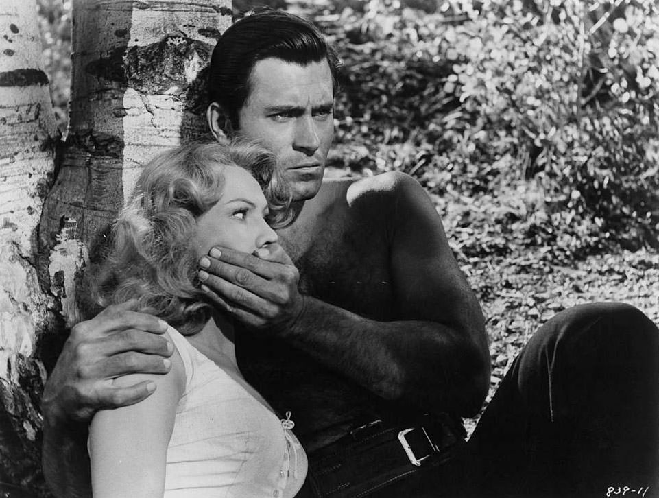 Virginia Mayo's mouth is held shut by Clint Walker in a scene from the film 'Fort Dobbs', 1958.