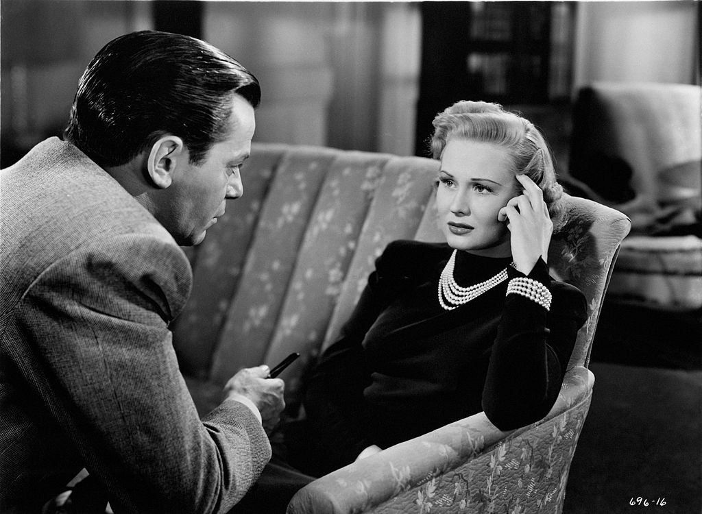Virginia Mayo seated on the sofa, looking into eyes of Robert Hutton in a scene from the movie 'Smart Girls Don't Talk', 1948.