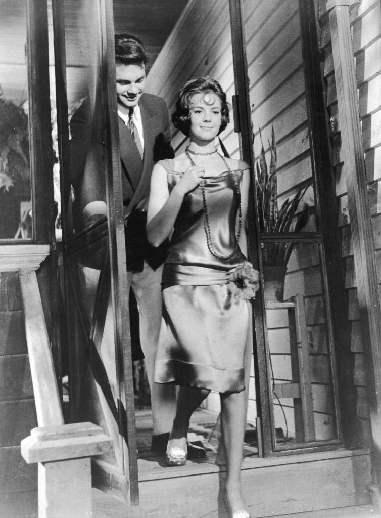Warren Beatty with Natalie Wood walk through a doorway in a still from the film, 'Splendor In The Grass,' 1961.