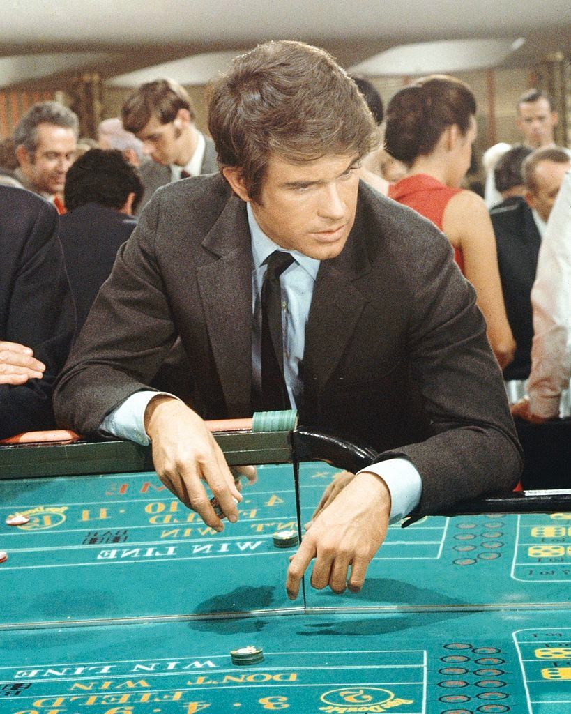 Warren Beatty leaning over a craps table in a publicity still issued for the film, 'Kaleidoscope', 1966.
