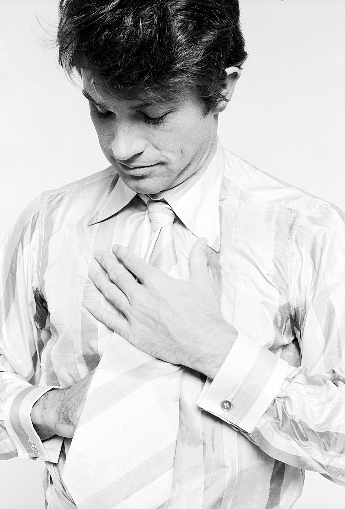 Warren Beatty as he knots his necktie, 1960s
