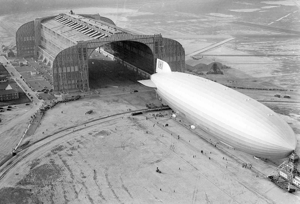 The German-built zeppelin Hindenburg trundles into the U.S. Navy hangar, its nose hooked to the mobile mooring tower, at Lakehurst, New Jersey, on May 9, 1936.