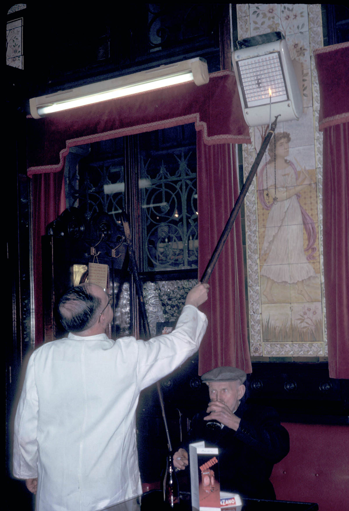 Man adjusting gas heater at Bruxelles Bar 1964 Man adjusting gas heater at Bruxelles Bar 1964