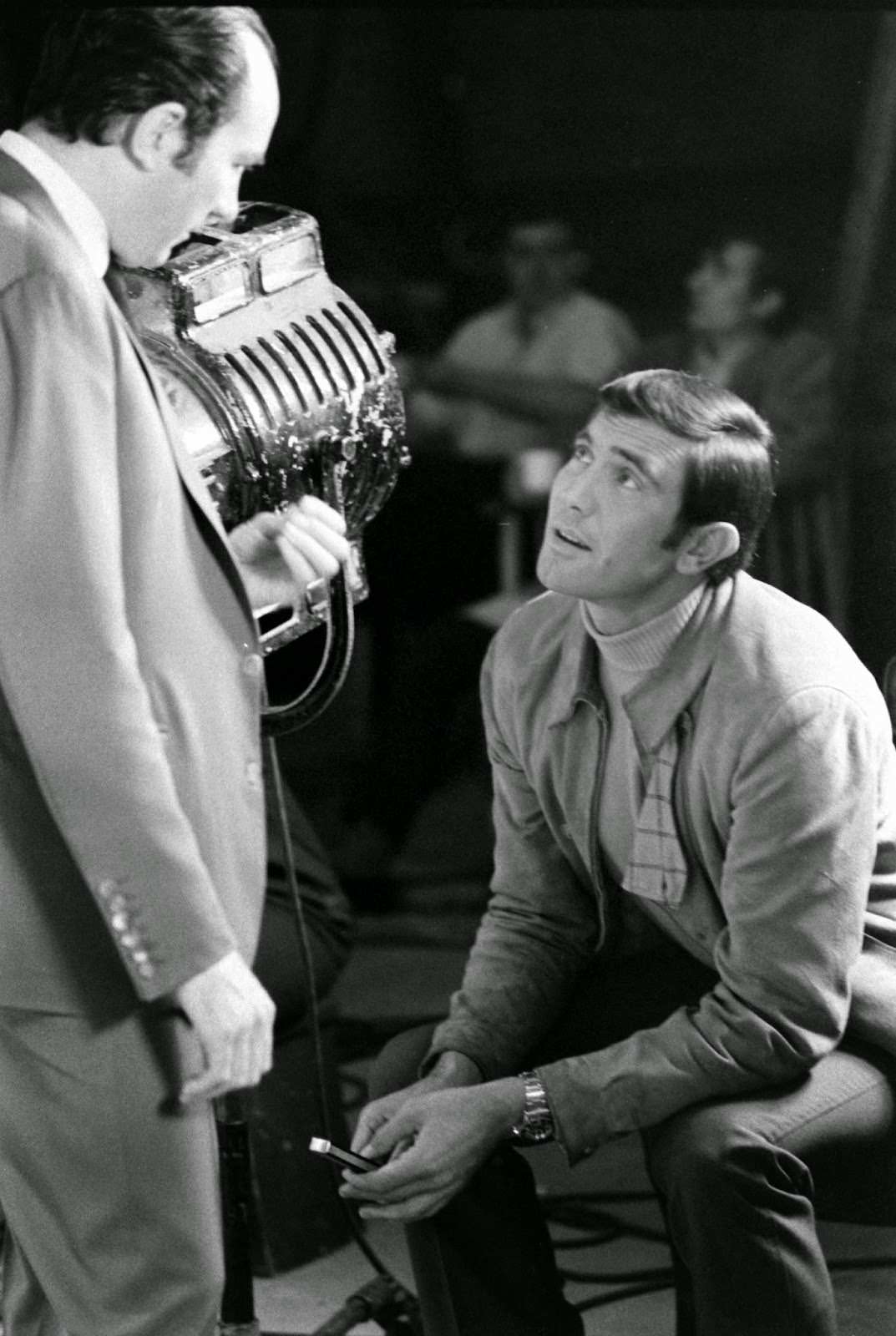 James Bond hopeful George Lazenby fiddles with a knife while chatting with Bond director Peter R. Hunt, 1967.