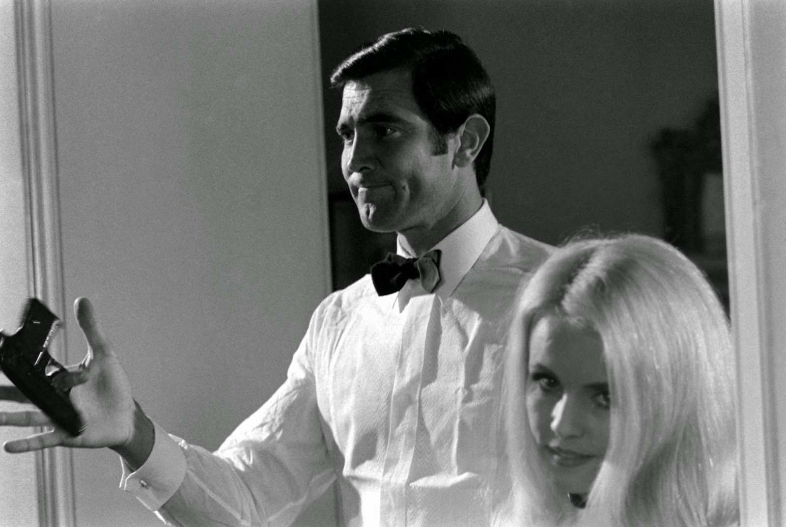George Lazenby twirls a gun beside potential Bond Girl Marie-France Boyer, 1967.