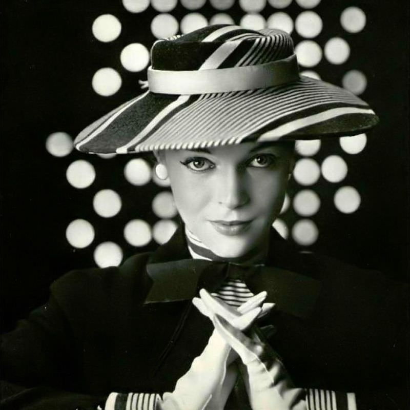 Joan Olson in striped gray and white straw hat worn with matching jacket by Jean Barthet, 1953