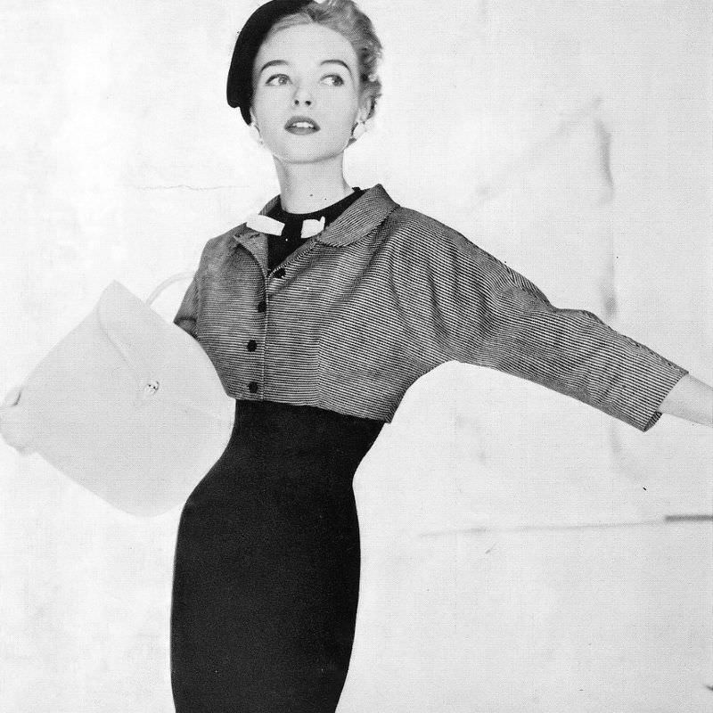 Joan Olson in black cotton alpaca sheath topped by a black and white striped bolero by Jerry Gilden, Vogue, July 1954