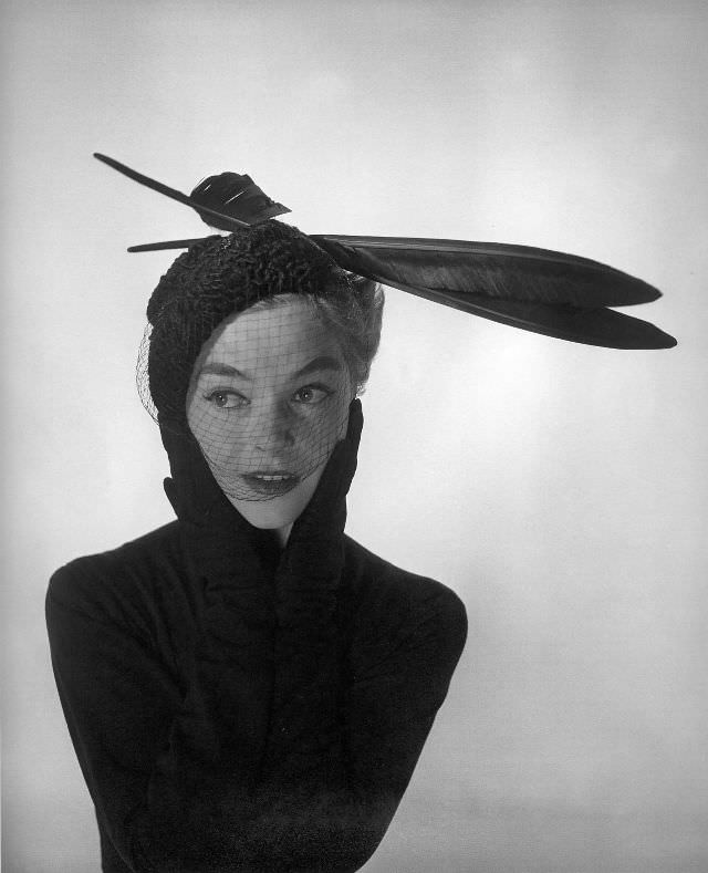 Joan Olson is wearing veiled astrakhan hat with two large feathers by Jacques Fath, September 1952