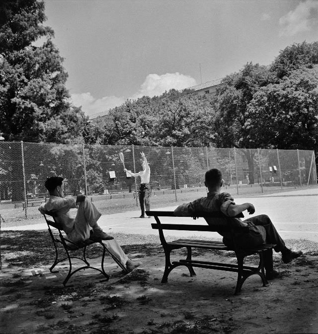 Playing tennis in the park in front of the U.S. Department of Commerce building on Sunday afternoon, Washington, D.C., June 1942