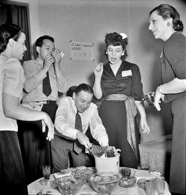 Serving punch during an evening party at the home of a government artist, Washington, D.C. June, 1942