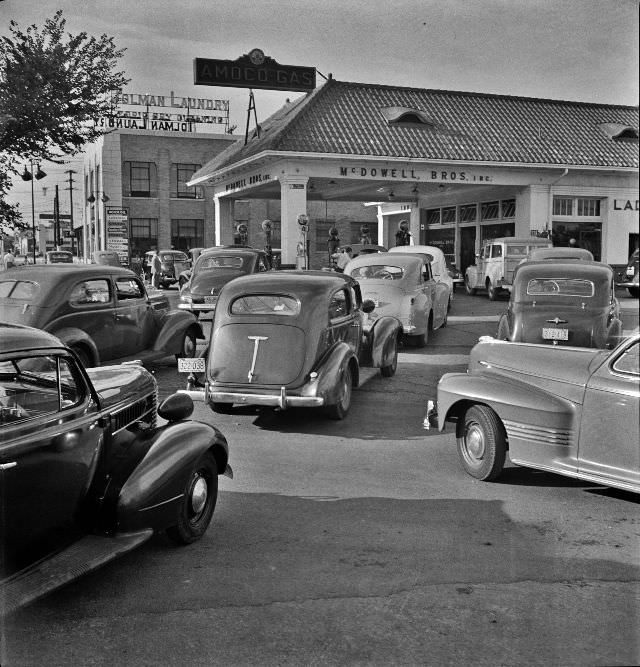 At 7 a.m. on June 21st, the day before stricter gas rationing was enforced, cars were pouring into this gas station on upper Wisconsin Ave., Washington, D.C., 1942