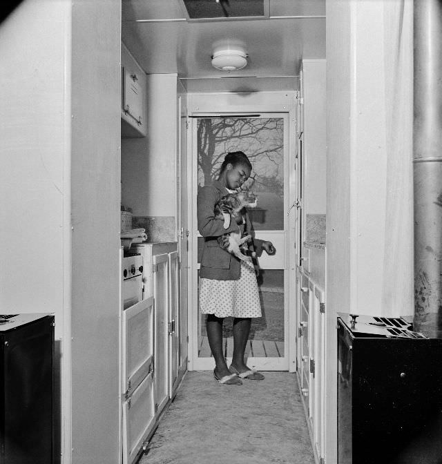 Young girl with her cat in the kitchen of her home,Arlington, Virginia, April 1942