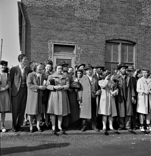 Workers waiting for a bus home at a busy intersection at four in the afternoon, Baltimore, Maryland, April 1943