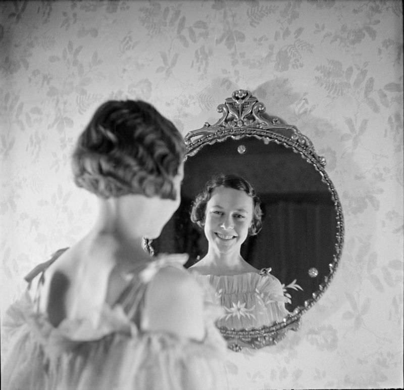 A young woman standing and looking into a mirror