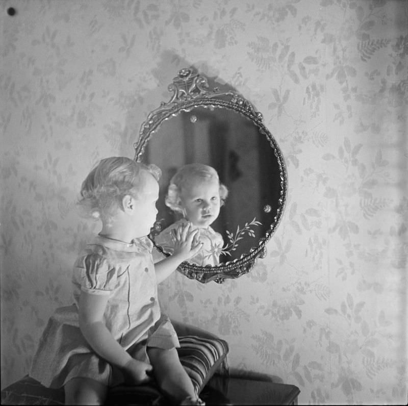 A girl sitting on pillow looking into mirror