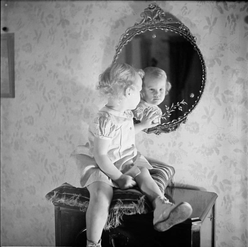 A girl sitting on pillow looking into mirror