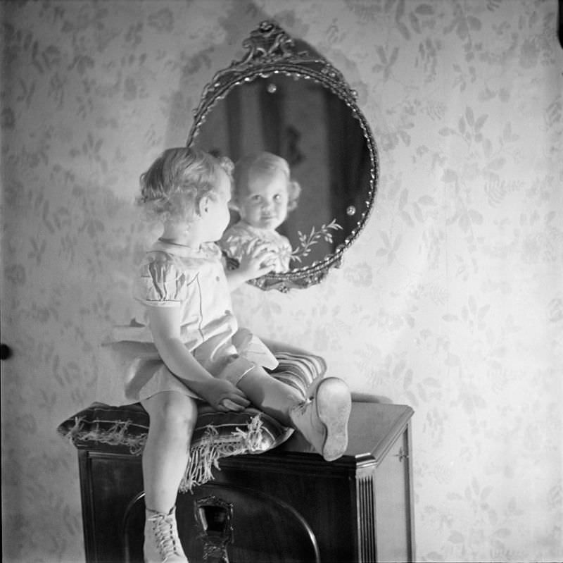 A girl sitting on pillow looking into mirror