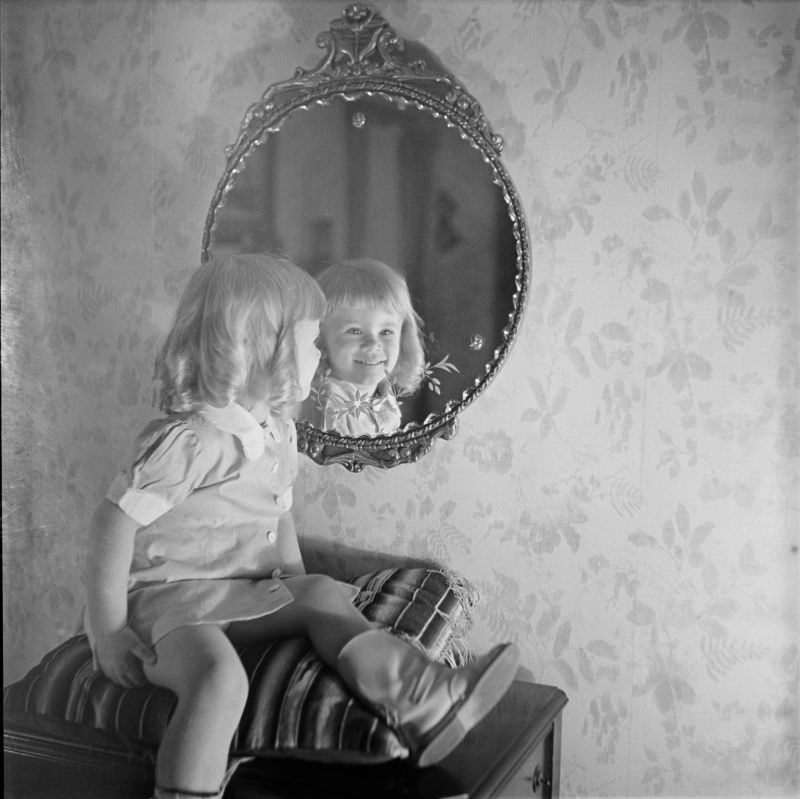 A girl sitting on pillow looking into mirror