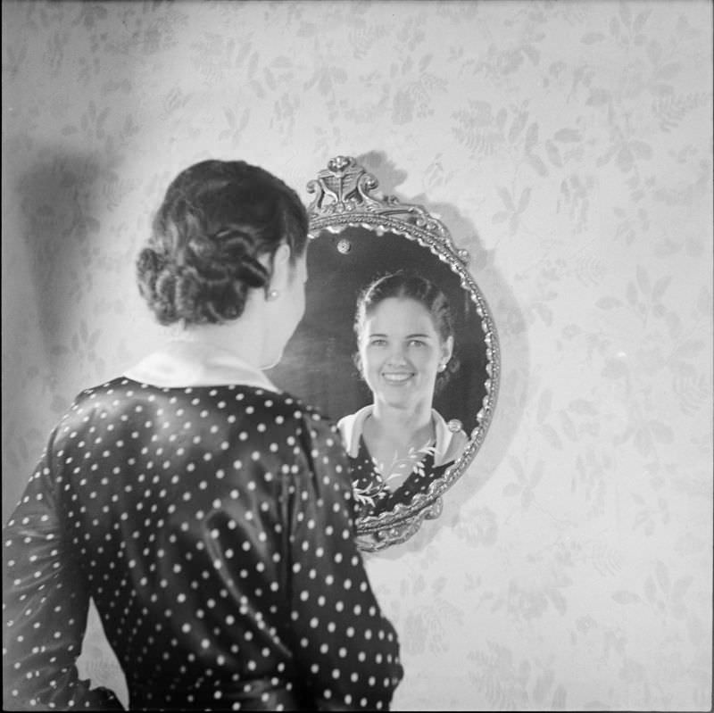 A woman standing and looking into a mirror