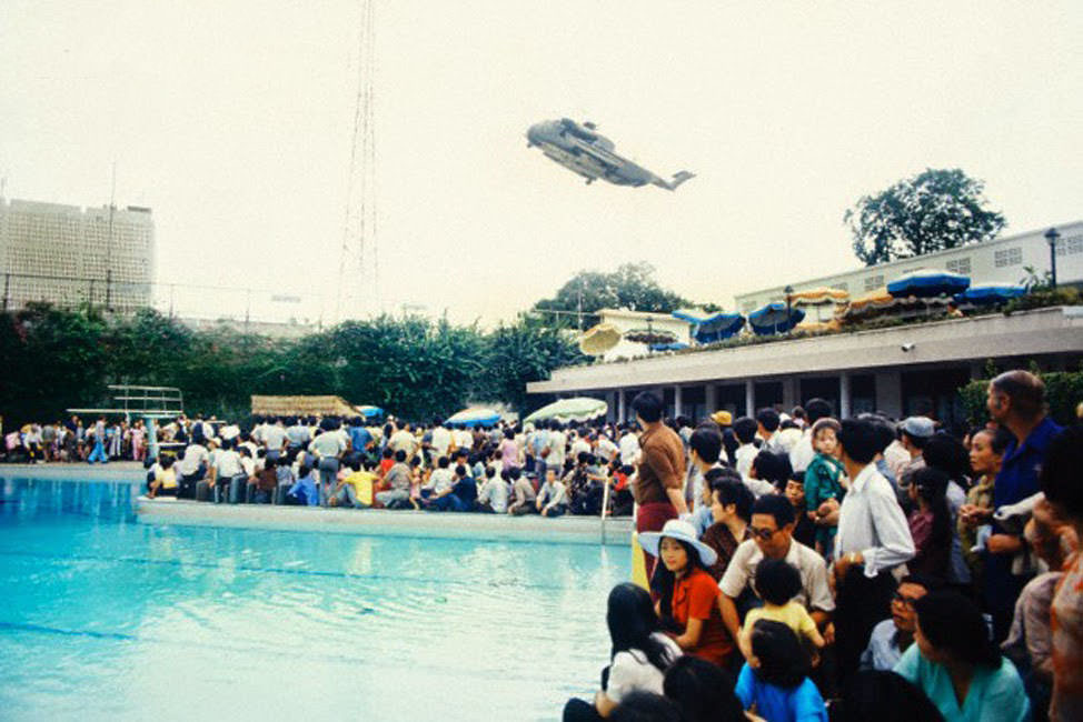 Crowds of Vietnamese and Western evacuees wait around the swimming pool inside the American Embassy compound in Saigon hoping to escape Vietnam via helicopter before the arrival of North Vietnamese troops.