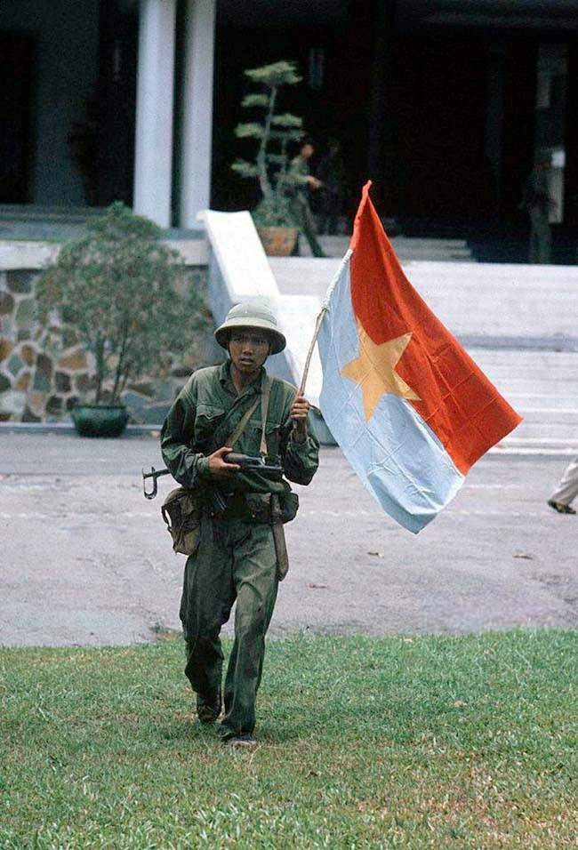 Taken of the presidential palace. North - Vietnamese officer holding a flag of the G.R.P. April 30, 1975.