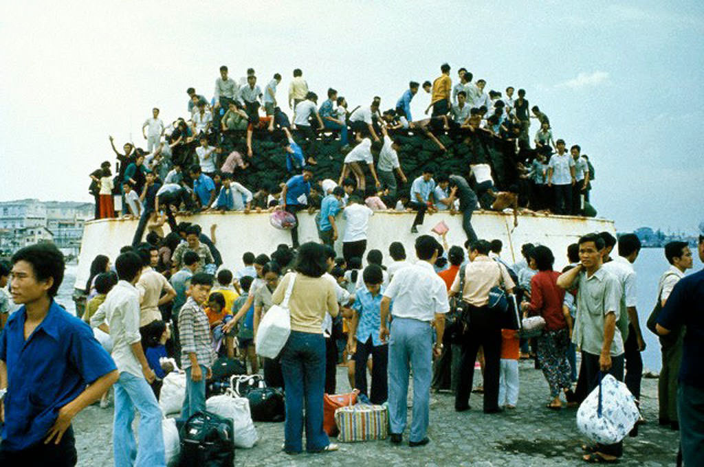 South Vietnamese clamber aboard barges in the port of Saigon in an attempt to escape from advancing North Vietnamese troops on the day of the Fall of Saigon that ended the Vietnam War