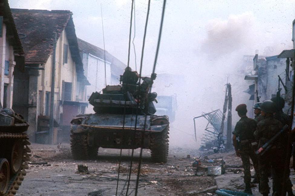 A tank through the streets of the city destroyed, during the Tet offensive, the Vietnamese new year night.