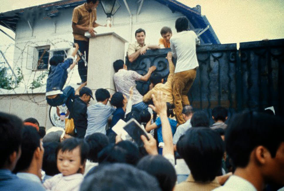 Desperate South Vietnamese citizens try to scale the walls of the American Embassy in a vain attempt to flee Saigon and avancing North Vietnamese troops .