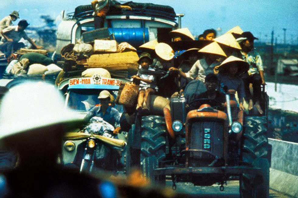 South Vietnamese refugees cling to vehicles along Highway 1.