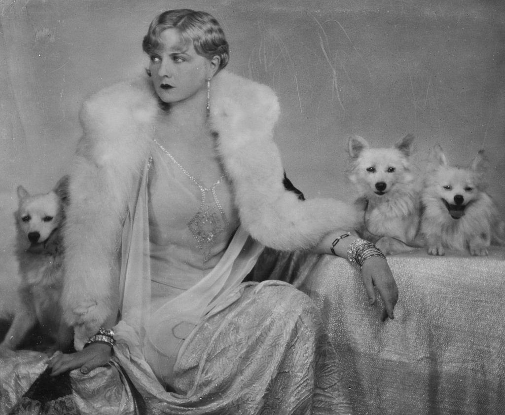 Alice Terry wearing a fur coat with her pet dogs, 1925.