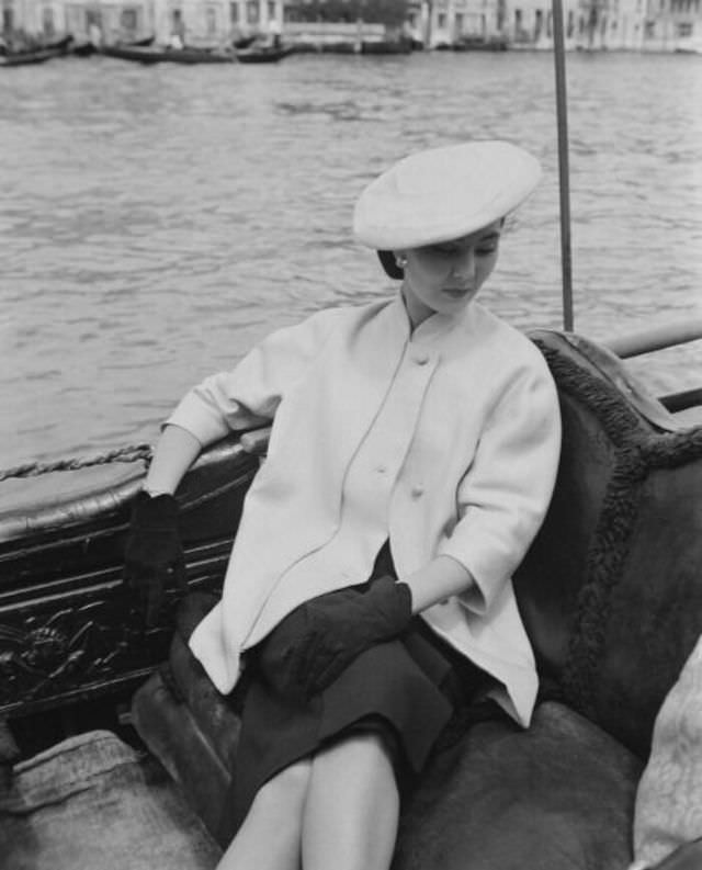 Alla in Christian Dior's loose-fitting jacket with mandarin-collar sits in a gondola, Venice, June 1951