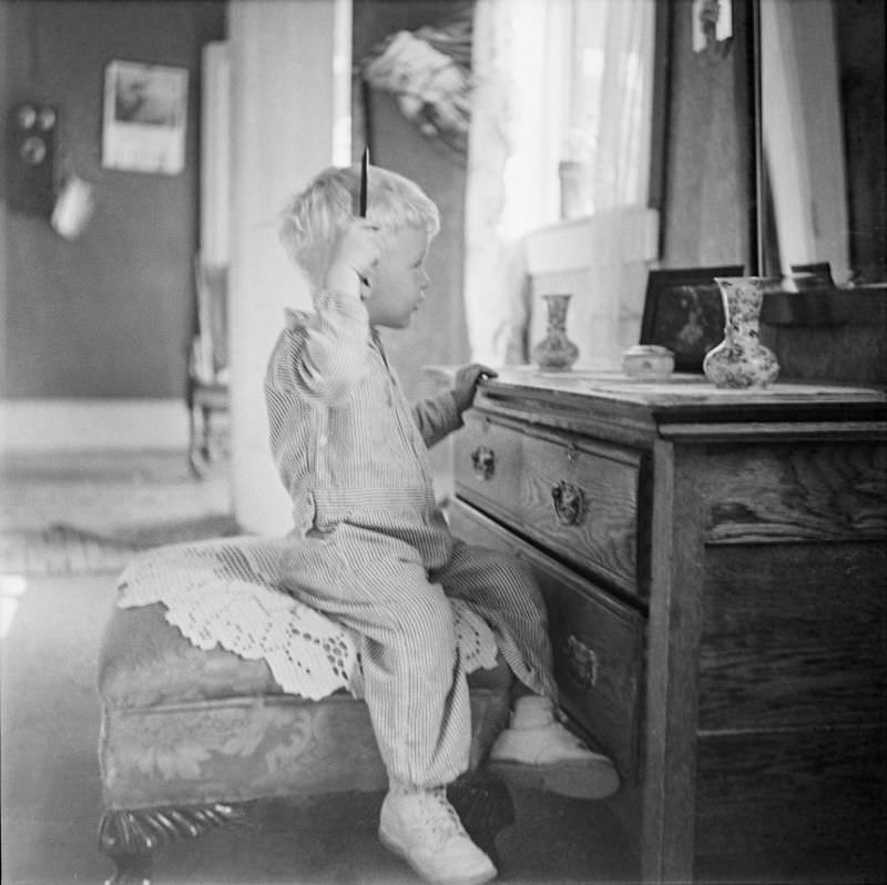 Boy sitting in front of a mirror, holding a comb